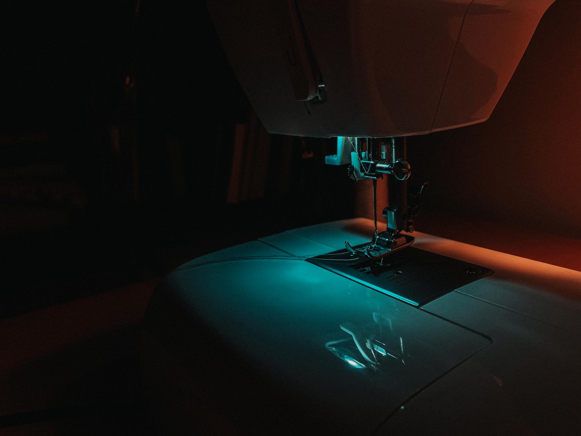 Artist hands stitching on an illuminated workbench