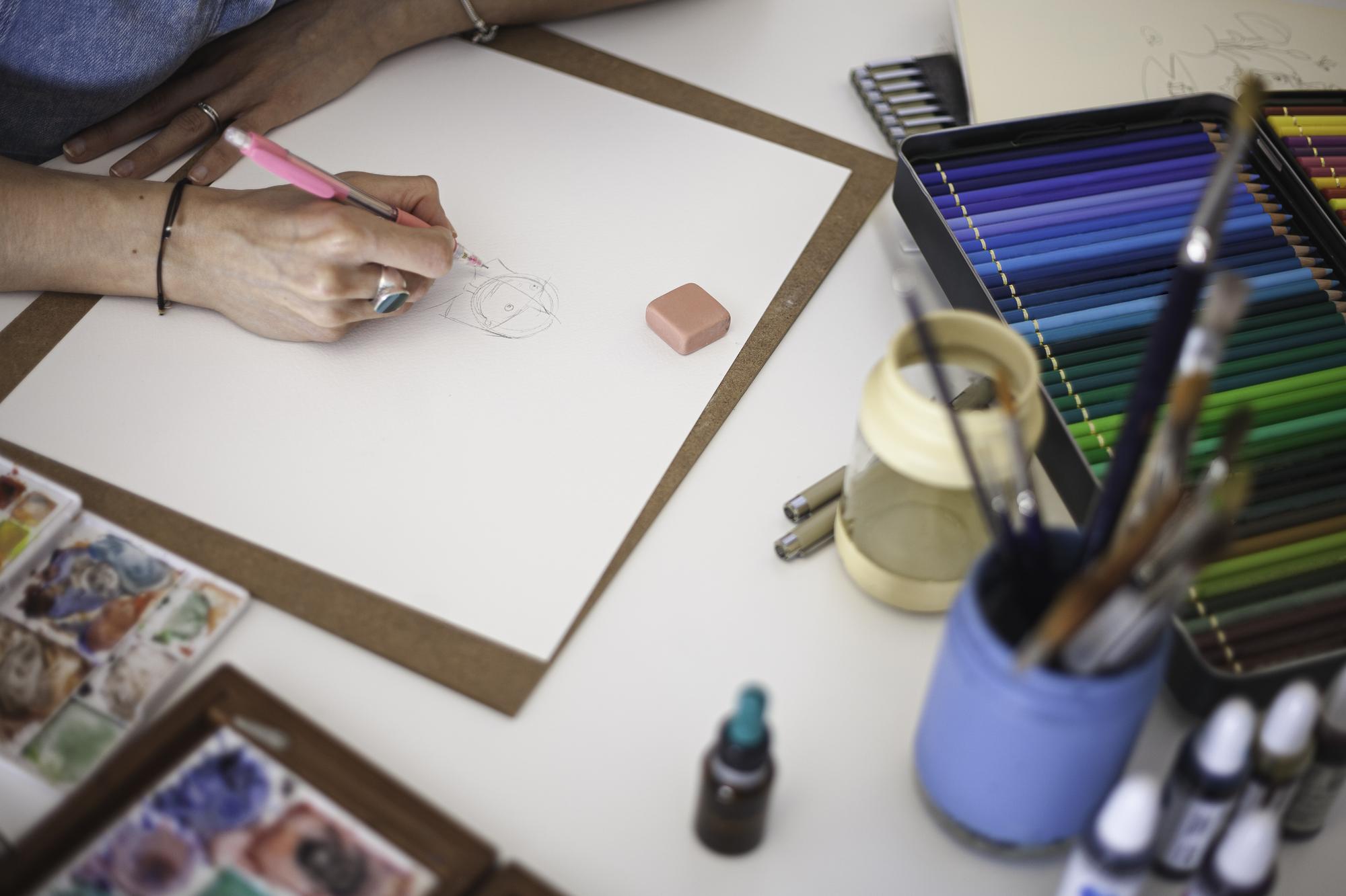 Designer sketch beside a stitched sample on table